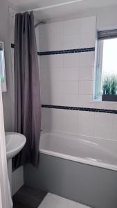 a bathroom with a white tub and a sink at Spring Grove in Hull
