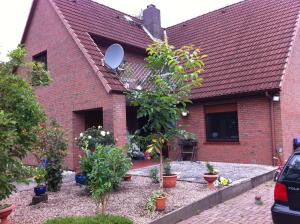 Pension A1 Stuckenborstel في Sottrum: بيت من الطوب الأحمر والنباتات أمامه