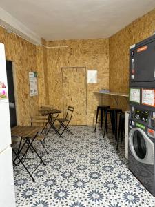 a laundry room with a washer and dryer and tables and chairs at Backpackers La Gaditana in Alhaurín el Grande