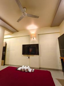 een kamer met twee handdoeken en een tv aan de muur bij Hotel Vaishnavi in Solapur