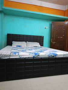 a bed in a room with a blue wall at Comfort Inn Homestay in Guwahati