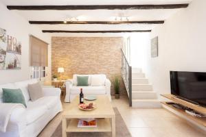 a living room with a white couch and a tv at Home2Book Charming Cottage Juanita Among Avocados in La Orotava