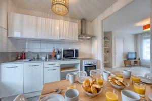 a kitchen with a table with plates of food on it at #HQ Les Zenith Colors Agréable T4 at SMH in Saint-Martin-dʼHères +17 photos