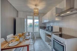 a kitchen with a wooden table with a counter top at #HQ Les Zenith Colors Agréable T4 at SMH in Saint-Martin-dʼHères