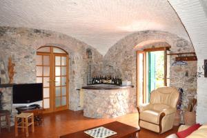 sala de estar con pared de piedra y TV en Casa Lia, en Arcola