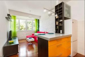 uma cozinha com armários laranja e um sofá vermelho em Apartment Put Meja em Split