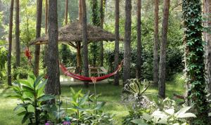 a hammock in the middle of a garden with trees at Vila Dunavski Raj in Golubac