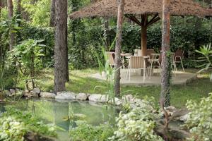 a garden with a table and chairs and a pond at Vila Dunavski Raj in Golubac