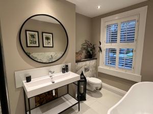 ein Badezimmer mit Waschbecken und Spiegel in der Unterkunft Stunning Town House in City Centre- Free Parking! in Bath + 38 Fotos