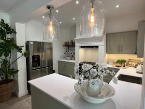 eine Küche mit einer Vase mit Blumen auf einer Theke in der Unterkunft Stunning Town House in City Centre- Free Parking! in Bath