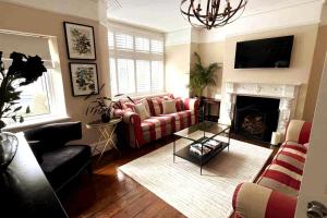 ein Wohnzimmer mit Couch und Kamin in der Unterkunft Stunning Town House in City Centre- Free Parking! in Bath