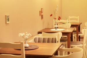 a dining room with wooden tables and white chairs at Vila Dunavski Raj in Golubac
