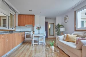 Una cocina y una sala de estar con un sofá y una mesa. en Apartamento Porto Foz, en Foz