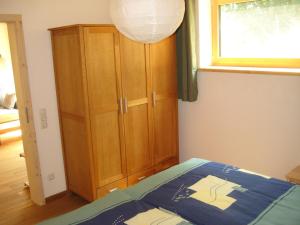 a bedroom with a bed and a wooden cabinet at Ferienwohnung Ameis in Heiligenstadt +3 photos
