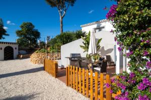 a patio with a table and chairs and flowers at El Rinconcito in Jávea