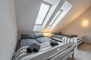 two beds in a room with skylights at Apartamenty Nad Żylicą przy deptaku - Dream Apart in Szczyrk