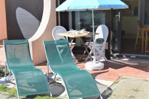 a table and chairs and an umbrella on a patio at Appart Studio 2 couchages PORT LEUCATE NATURISME PL010-423 in Leucate-Plage +2 photos