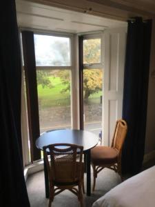 une pièce avec une table, des chaises et une fenêtre dans l'établissement Budget room 10min Walk to Swansea Centre 1, à Swansea