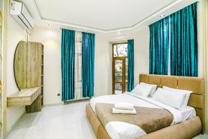 Un dormitorio con una cama grande con cortinas azules. en MAGNIUM Apartment in Nizami st, en Baku