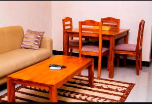 a living room with a couch and a table and chairs at Dodoma Central Apartments in Dodoma