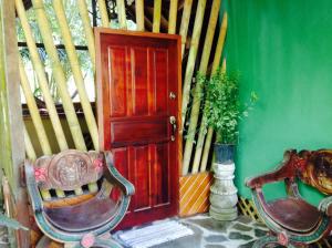 una habitación con una puerta y dos sillas y una planta en Casa Manglar Villa, en Puerto Jiménez