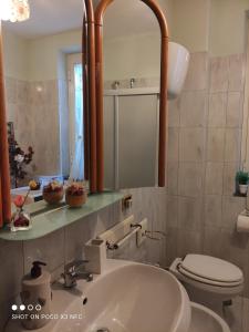 a bathroom with a sink and a toilet and a mirror at Appartamento GALY Spoleto in San Venanzia