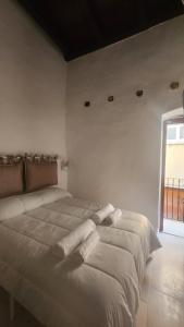 a bedroom with two beds with white sheets and a window at La Maison De Poupée in Bari