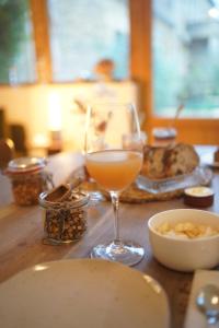een glas wijn zittend op een tafel met eten bij MAISON LOU PIADE Sarlat Your Luxury Farm Hôtel & Confidential place to stay in Sarlat in Sarlat-la-Canéda +25 foto's
