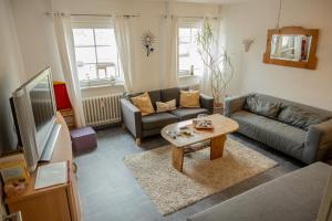 a living room with a couch and a table at Ferienwohnung & Apartment Am Steinbrunnen in Brauneberg