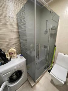 y baño con ducha y lavadora. en Cosmo Apartment, en Tiflis