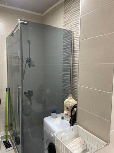 y baño con ducha y lavadora. en Cosmo Apartment, en Tiflis