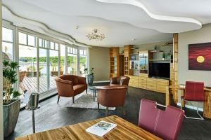 ein Wohnzimmer mit Stühlen und einem Tisch in der Unterkunft Strandhotel Prinz von Preussen in Zinnowitz