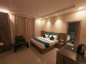 a hotel room with a bed and a mirror at Hotel Wild Rose - Dalhousie in Dalhousie