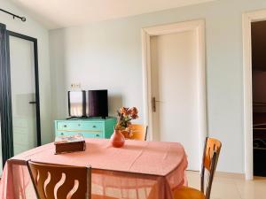 a dining room with a table with a vase on it at Infinity blue beach apartments - Renovated Apartments 2 Minutes from the Sea & Pool with Scenic Views in Tsilivi