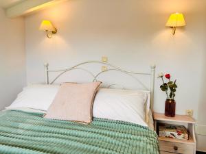 a bed with a green and white blanket and two lamps at Infinity blue beach apartments - Renovated Apartments 2 Minutes from the Sea & Pool with Scenic Views in Tsilivi