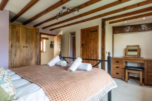 ein Schlafzimmer mit einem Bett mit weißen Kissen darauf in der Unterkunft The Threshing Barn - Stunning 5 Bedroom Retreat! in Sedgeberrow