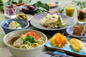 a table with plates of food and bowls of pasta at Art Hotel Ishigakijima in Ishigaki Island +138 photos