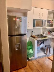 a kitchen with a stainless steel refrigerator and white cabinets at Beautiful stay in Abasto-Recoleta-O-P in Buenos Aires