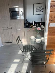 a kitchen with a table with flowers and a microwave at t Ateliertje Noort in Bergen +8 photos