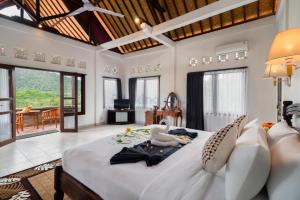 a bedroom with a large bed with two swans on it at The Kanjeng Signature Sidemen in Sidemen