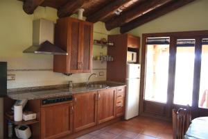 a kitchen with wooden cabinets and a sink and a window at Casa Plana in Colungo