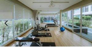 a living room filled with furniture and large windows at Peaceful Stay at MT Khlong Luang Self-Check-in in Khlong Luang