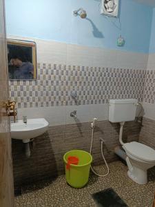a bathroom with a toilet and a sink at Bougainvilla in Alleppey