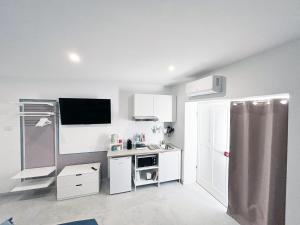 a white kitchen with a sink and a microwave at La Bouganville in Assisi