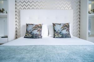 a bedroom with a white bed with two pillows at By the Sea - Nazaré in Nazaré