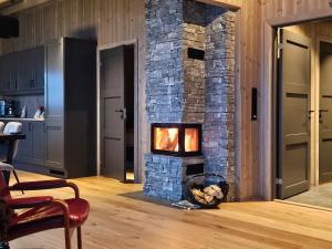 a living room with a stone fireplace in a kitchen at Utsikten in Sør-Fron +11 photos