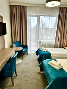 pokój hotelowy z 2 łóżkami, stołem i krzesłami w obiekcie Hotel Delicjusz w mieście Trzebaw +37 zdjęć