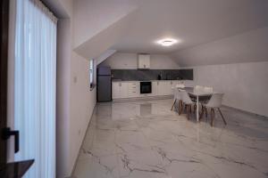 a kitchen with a table and chairs on a marble floor at Rustik in Volovăţ