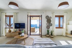 a living room with a couch and a table at Aigaio pool Villa, gaze the sunset over the Aegean sea in Glóssa