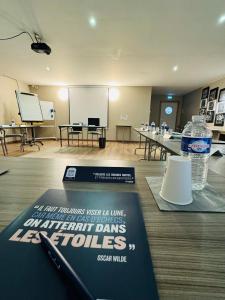 una sala conferenze con tavolo e bottiglia d'acqua di Kyriad Toulouse Sud - Roques a Roques Sur Garonne